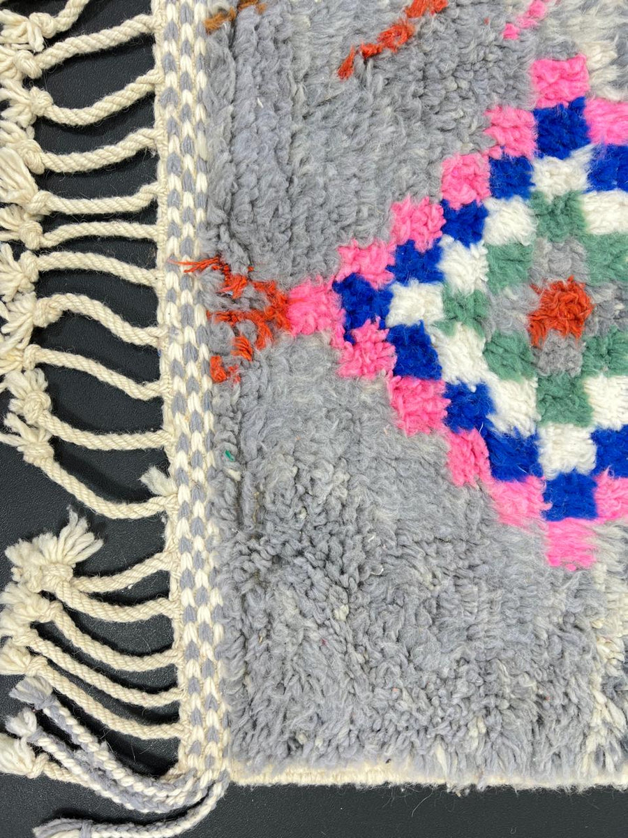 Colorful Moroccan wool runner rug with multicolor diamond patterns on a gray background