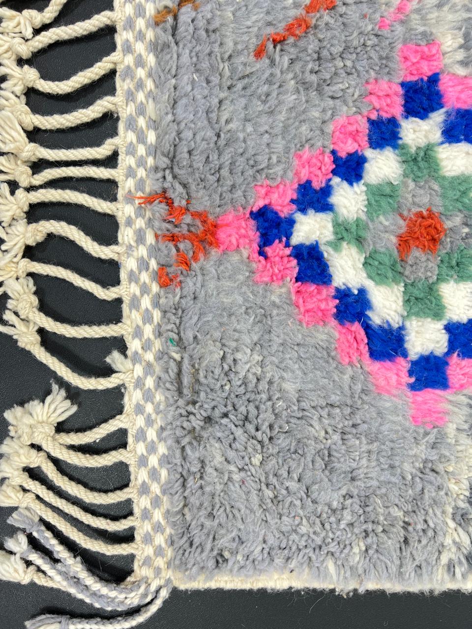 Colorful Moroccan wool runner rug with multicolor diamond patterns on a gray background