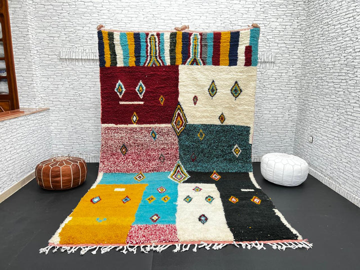 Colorful Moroccan wool rug with geometric patchwork and Berber motifs in red, turquoise, yellow, and black