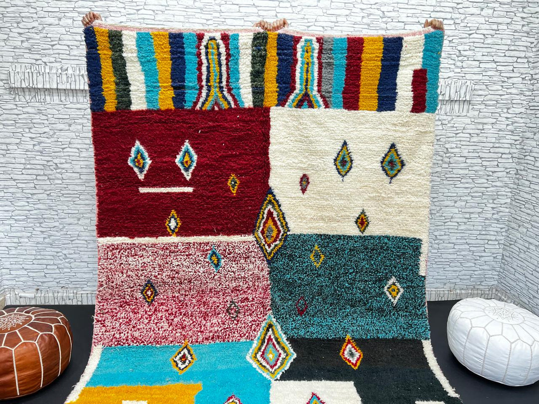 Colorful Moroccan wool rug with geometric patchwork and Berber motifs in red, turquoise, yellow, and black