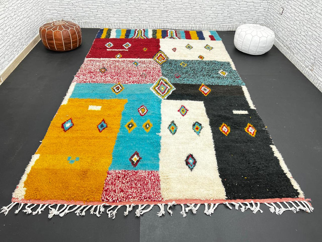 Colorful Moroccan wool rug with geometric patchwork and Berber motifs in red, turquoise, yellow, and black
