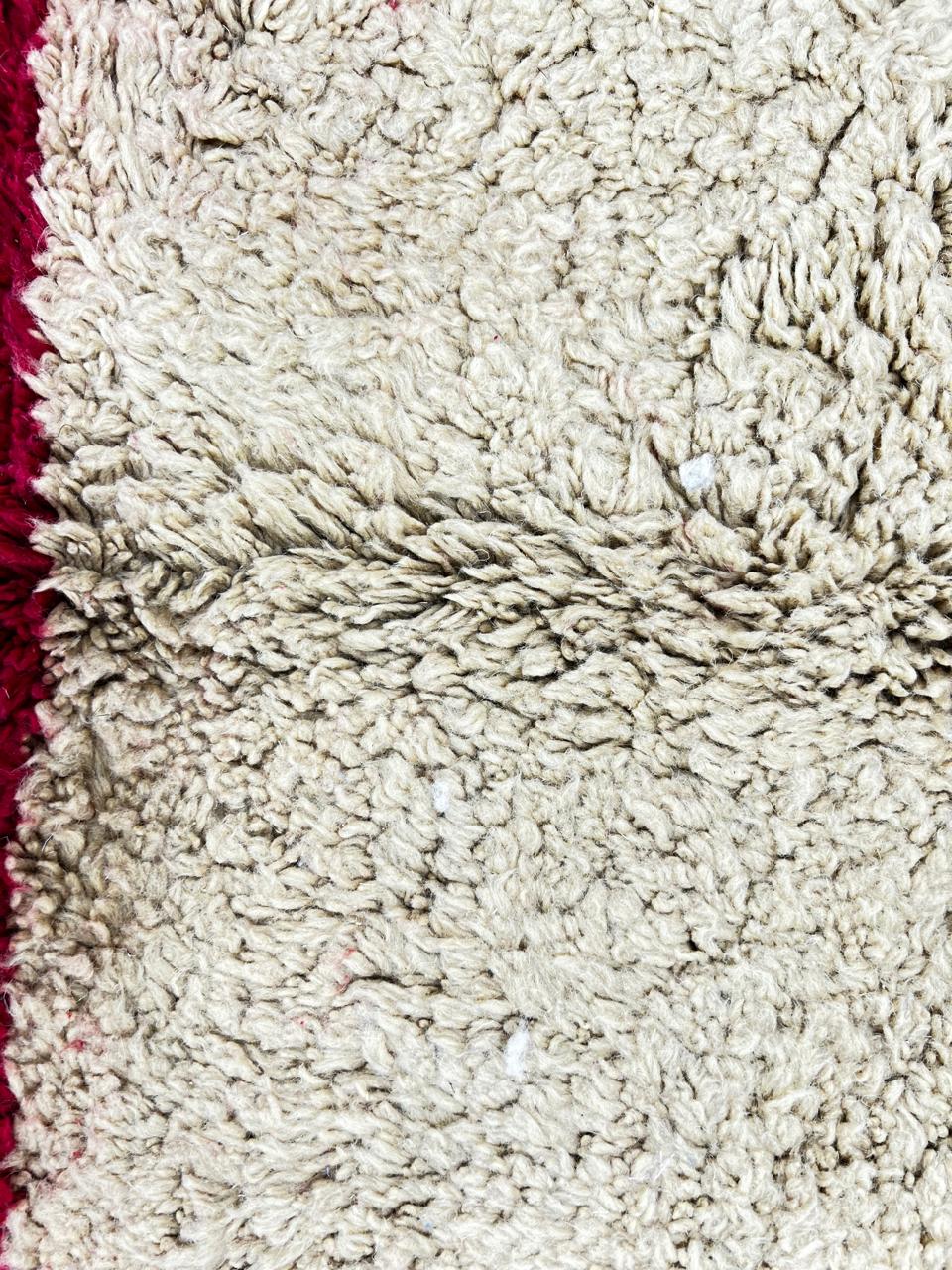 Colorful round Moroccan wool rug with handmade Berber design on white background.