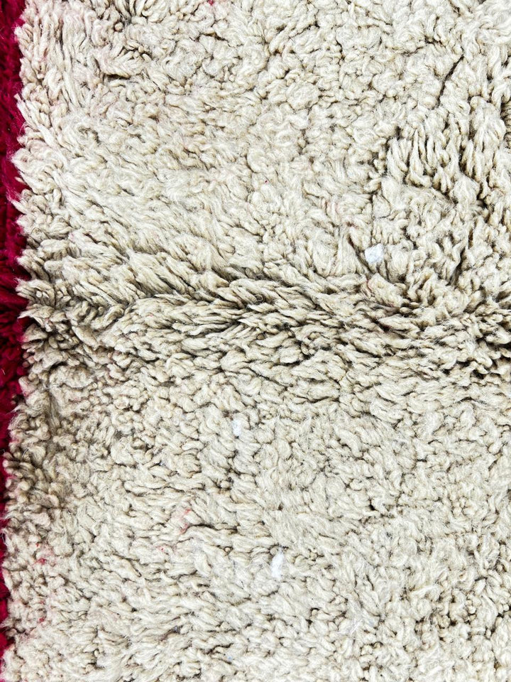 Colorful round Moroccan wool rug with handmade Berber design on white background.