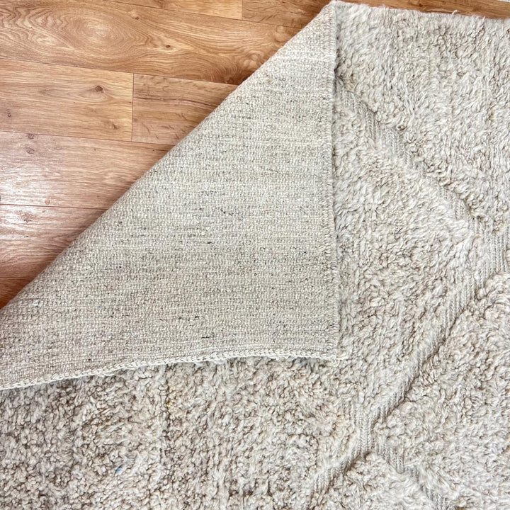 Cream Moroccan wool rug with diamond Berber pattern and plush texture