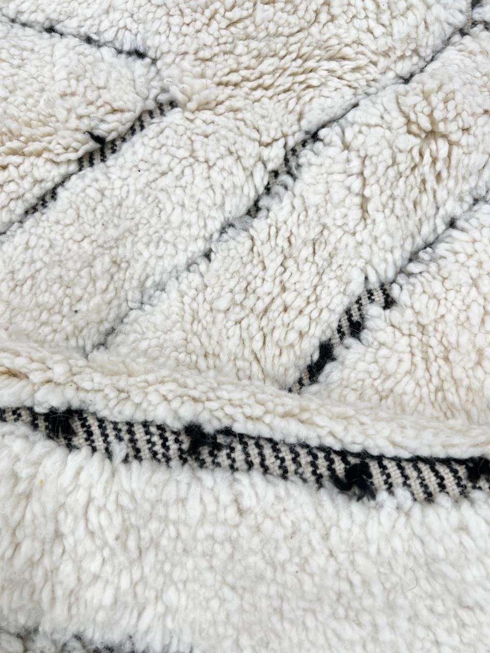 Handmade cream white Moroccan wool rug with black diamond lines and plush wool texture