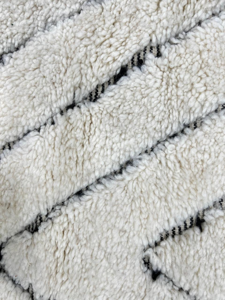 Handmade cream white Moroccan wool rug with black diamond lines and plush wool texture