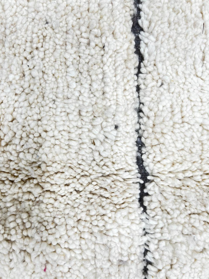 Cream Moroccan wool rug with charcoal gray geometric border and linear Berber pattern