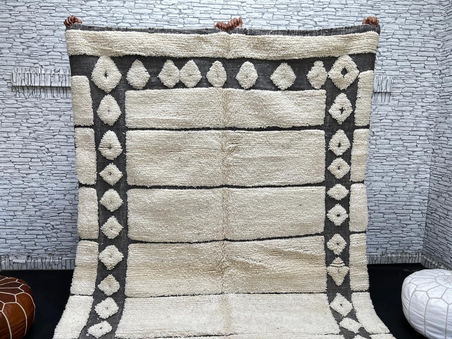 Cream Moroccan wool rug with charcoal gray geometric border and linear Berber pattern