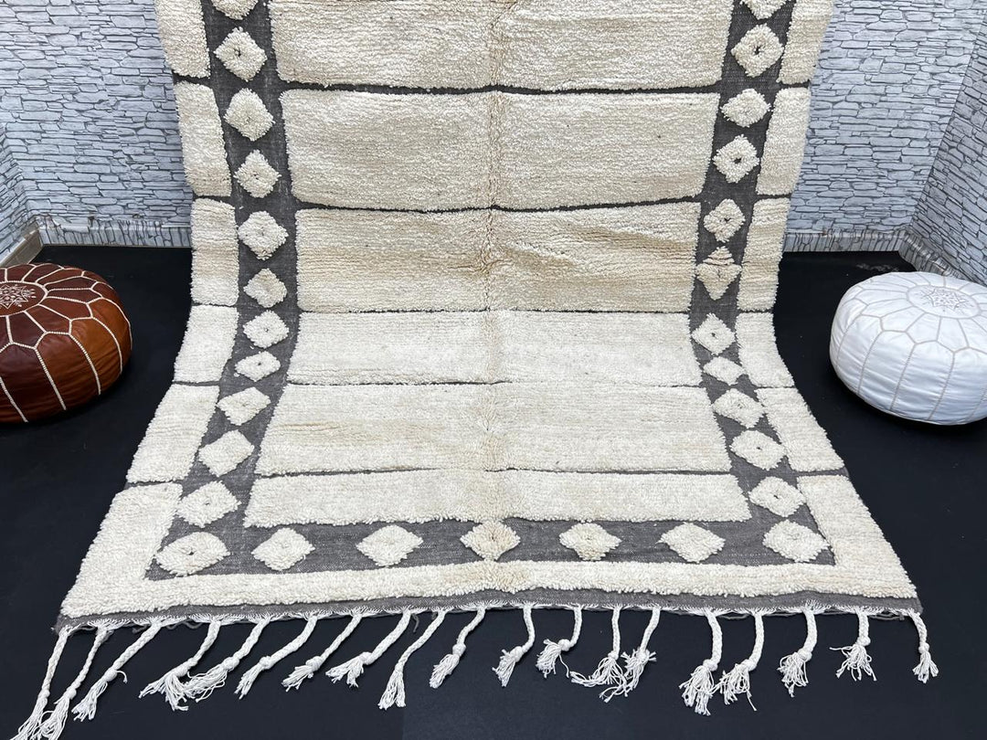 Cream Moroccan wool rug with charcoal gray geometric border and linear Berber pattern