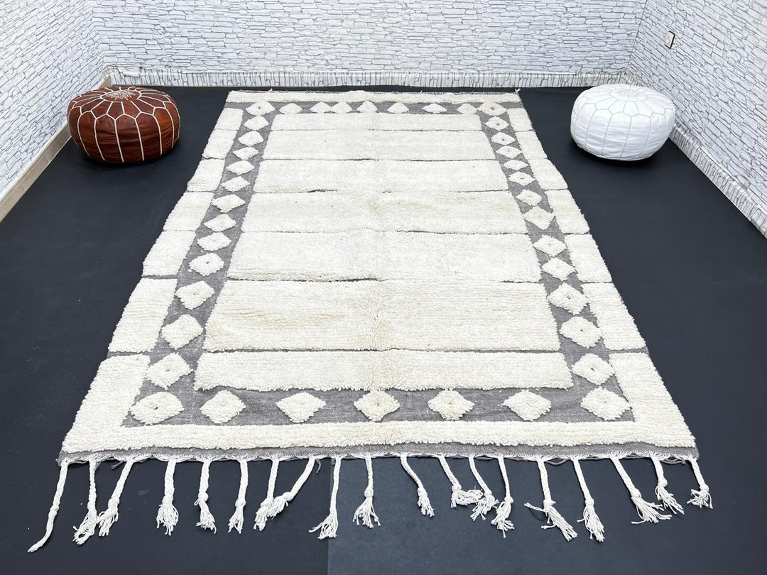 Cream Moroccan wool rug with charcoal gray geometric border and linear Berber pattern