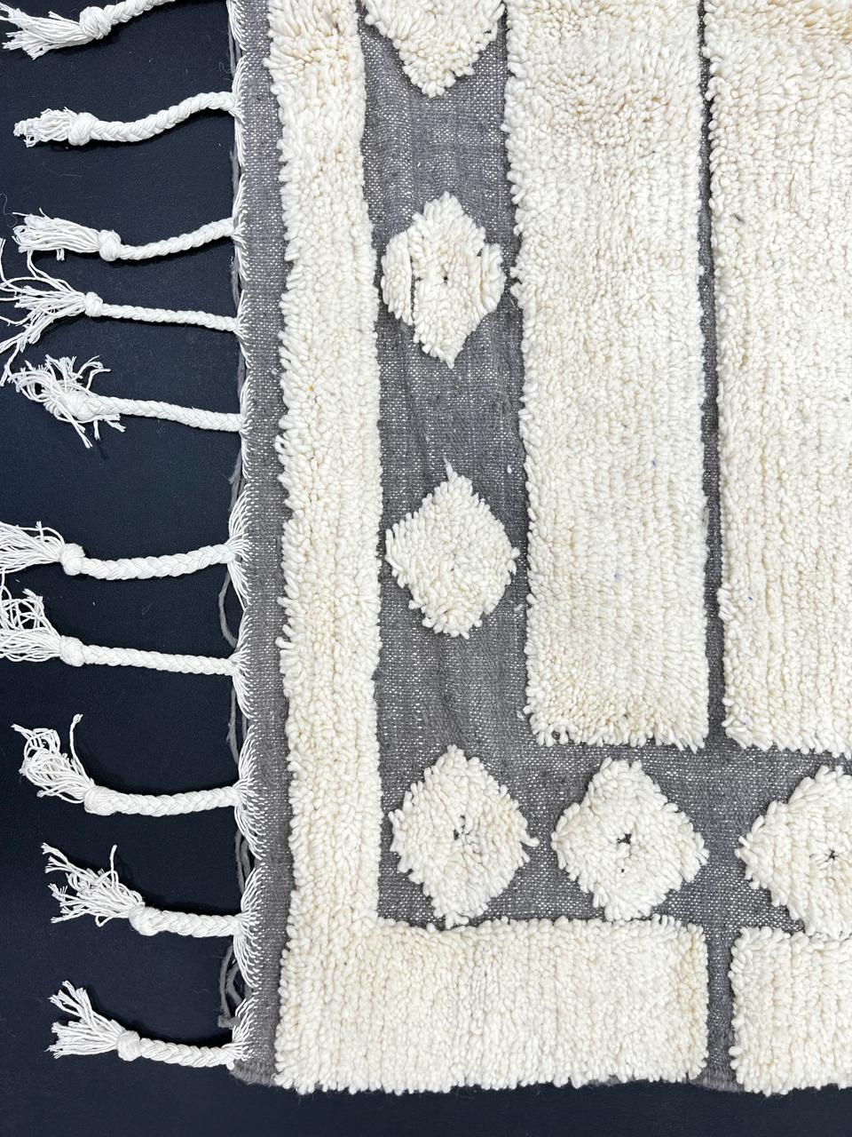 Cream Moroccan wool rug with charcoal gray geometric border and linear Berber pattern