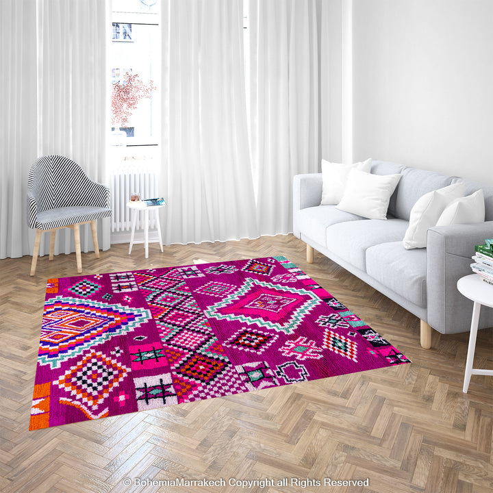 Pink Azilal Moroccan Rug in living room, vibrant tribal motifs in purple, orange, black on fuchsia background; handmade wool, traditional decor.
