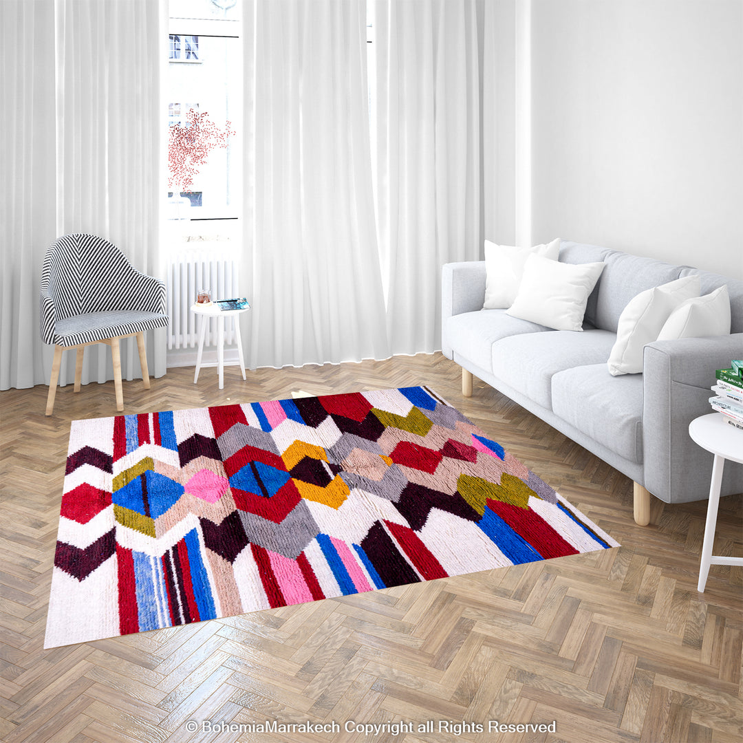 Colorful geometric Moroccan Azilal rug in modern living room with white sofa and curtains, showcasing vibrant diamond patterns.