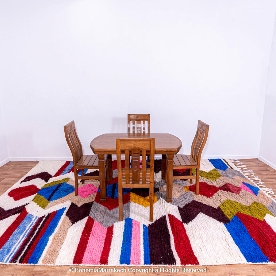 Colorful Geometric Azilal Rug with wooden dining set, showcasing vibrant Moroccan patterns. Perfect for bohemian or modern decor.