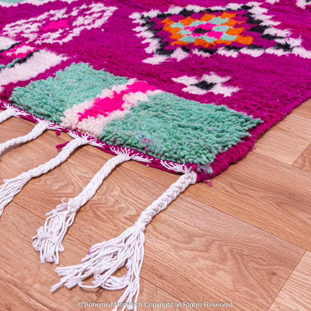 Colorful Pink Azilal Moroccan Rug with tribal geometric patterns in turquoise, orange, and violet, handcrafted wool carpet.