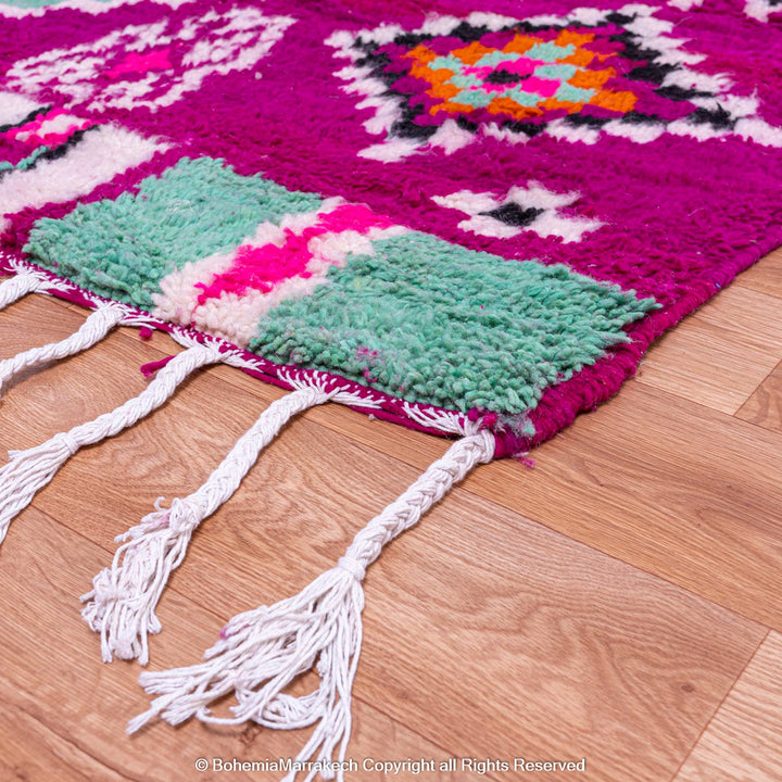 Colorful Pink Azilal Moroccan Rug with tribal geometric patterns in turquoise, orange, and violet, handcrafted wool carpet.