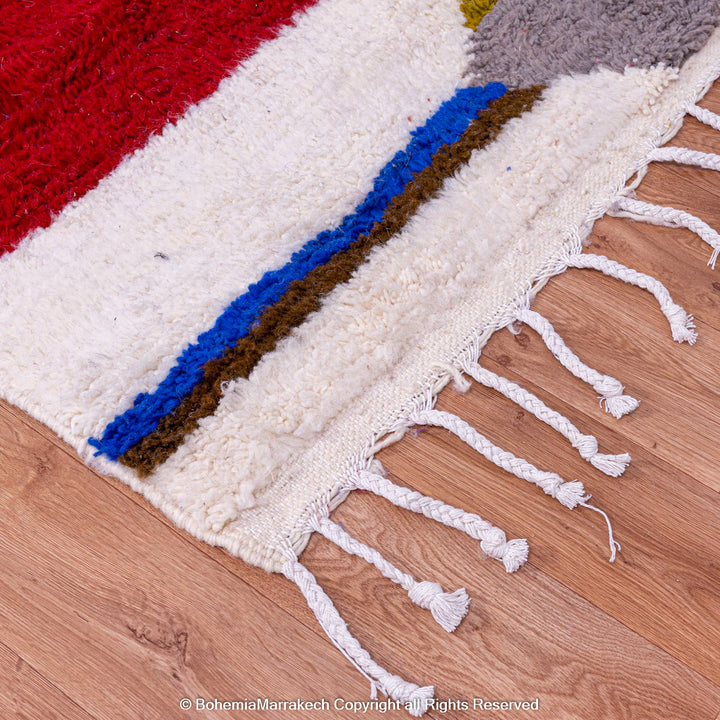 Colorful geometric Azilal wool Moroccan rug with vibrant red, blue, and green stripes on ivory background. Traditional Berber craftsmanship.
