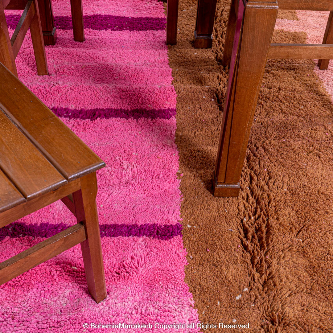 Colorful wool Moroccan shag rug with pink and brown geometric design, under wooden chairs, ideal for modern decor.