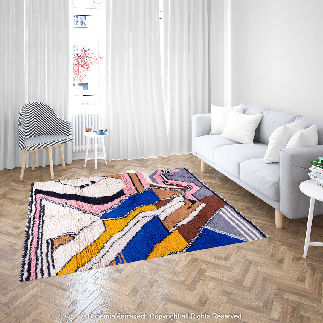 Colorful Abstract Moroccan Berber Wool Rug with zigzag patterns in blue, yellow, and pink, displayed in a modern living room setting.
