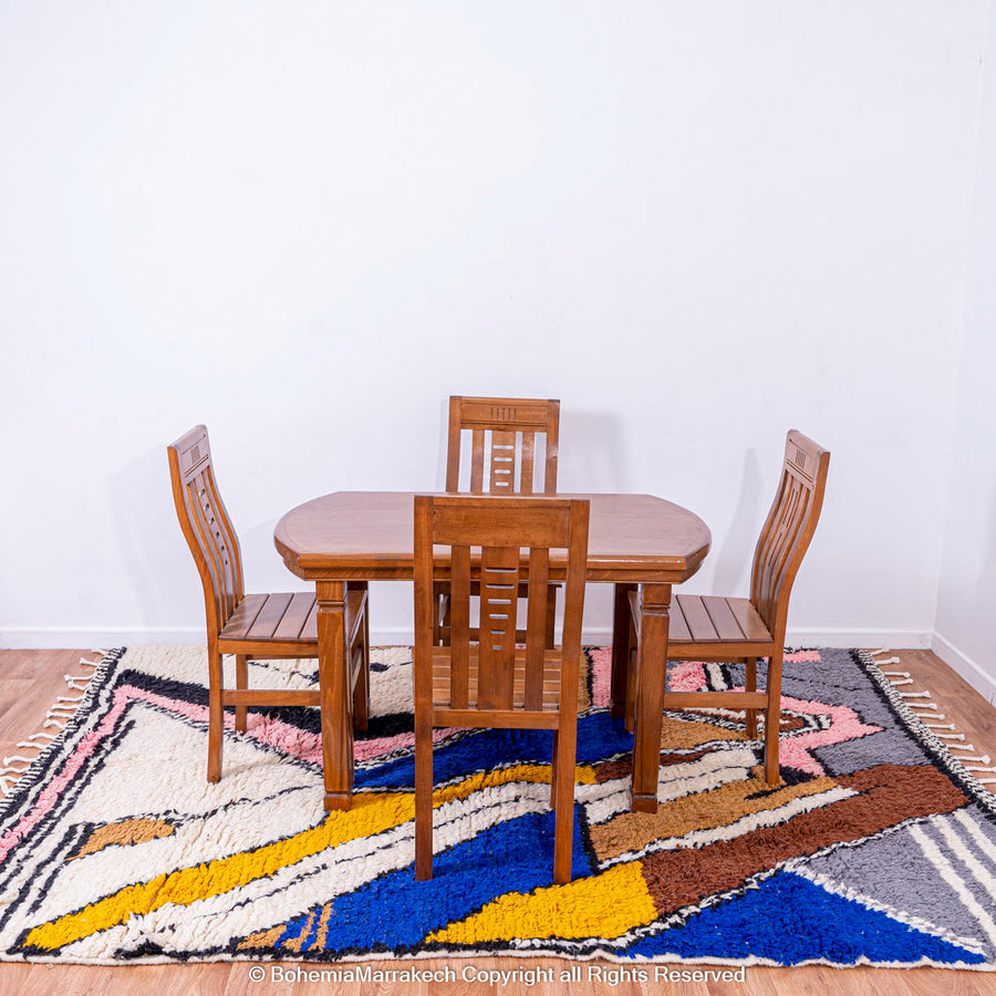 Colorful abstract Moroccan rug with vibrant zigzag patterns under wooden dining set