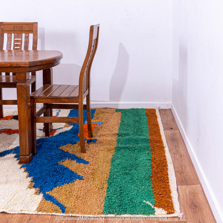 Colorful Moroccan rug with abstract camel design, handwoven from natural wool, complements dining room decor.