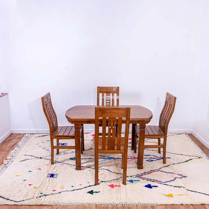 Dining room with wooden table set on colorful Azilal Moroccan wool tribal rug featuring Berber symbols.