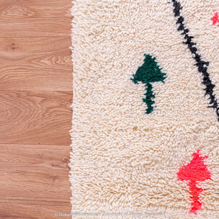 Close-up of Colorful Azilal Moroccan Rug with wool, diamond motifs, and vibrant colors like green and pink.