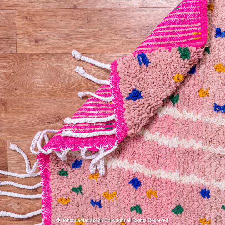 Pink and blue Moroccan rug with multicolor specks and geometric white lines
