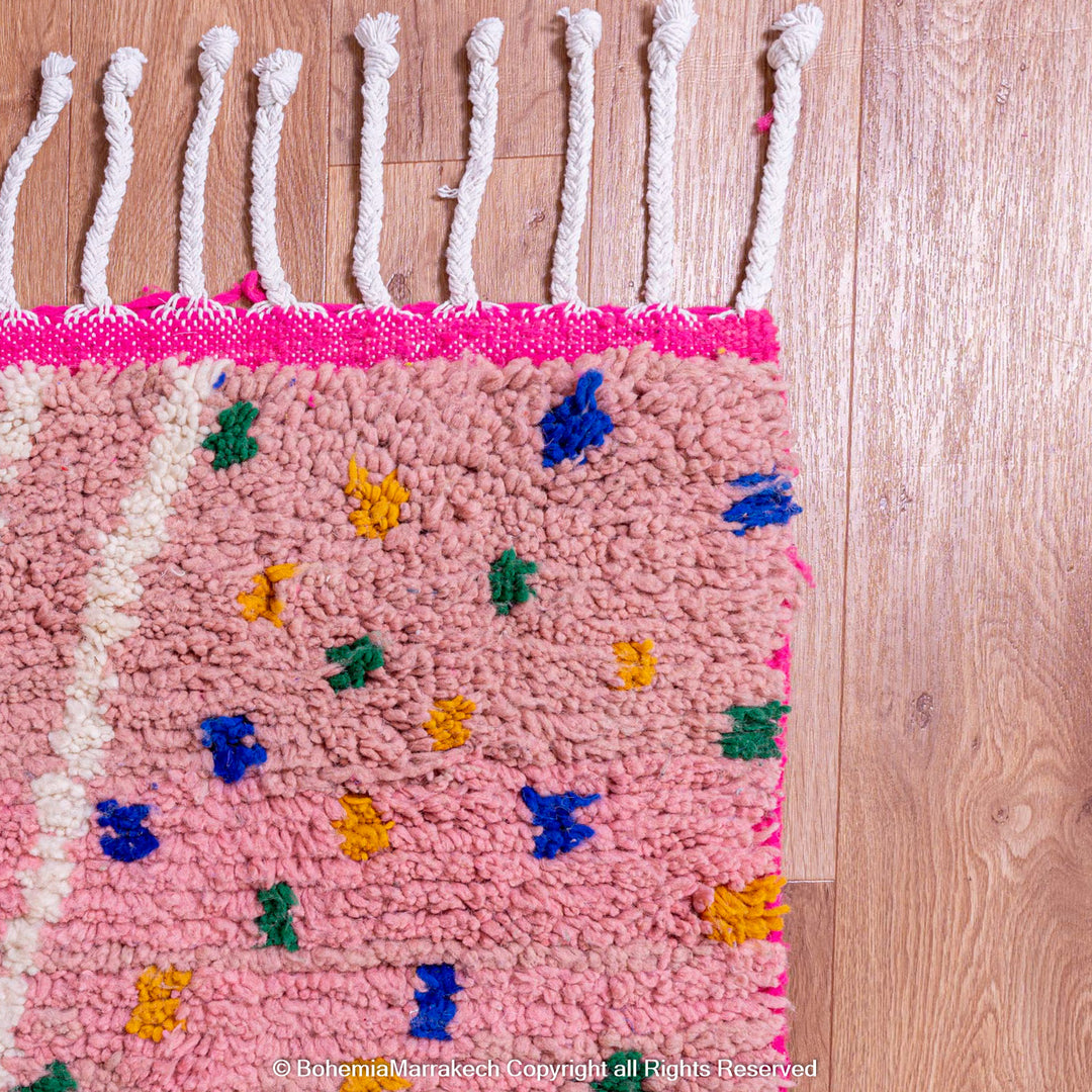 Pink and blue Moroccan rug with multicolor specks and geometric white lines