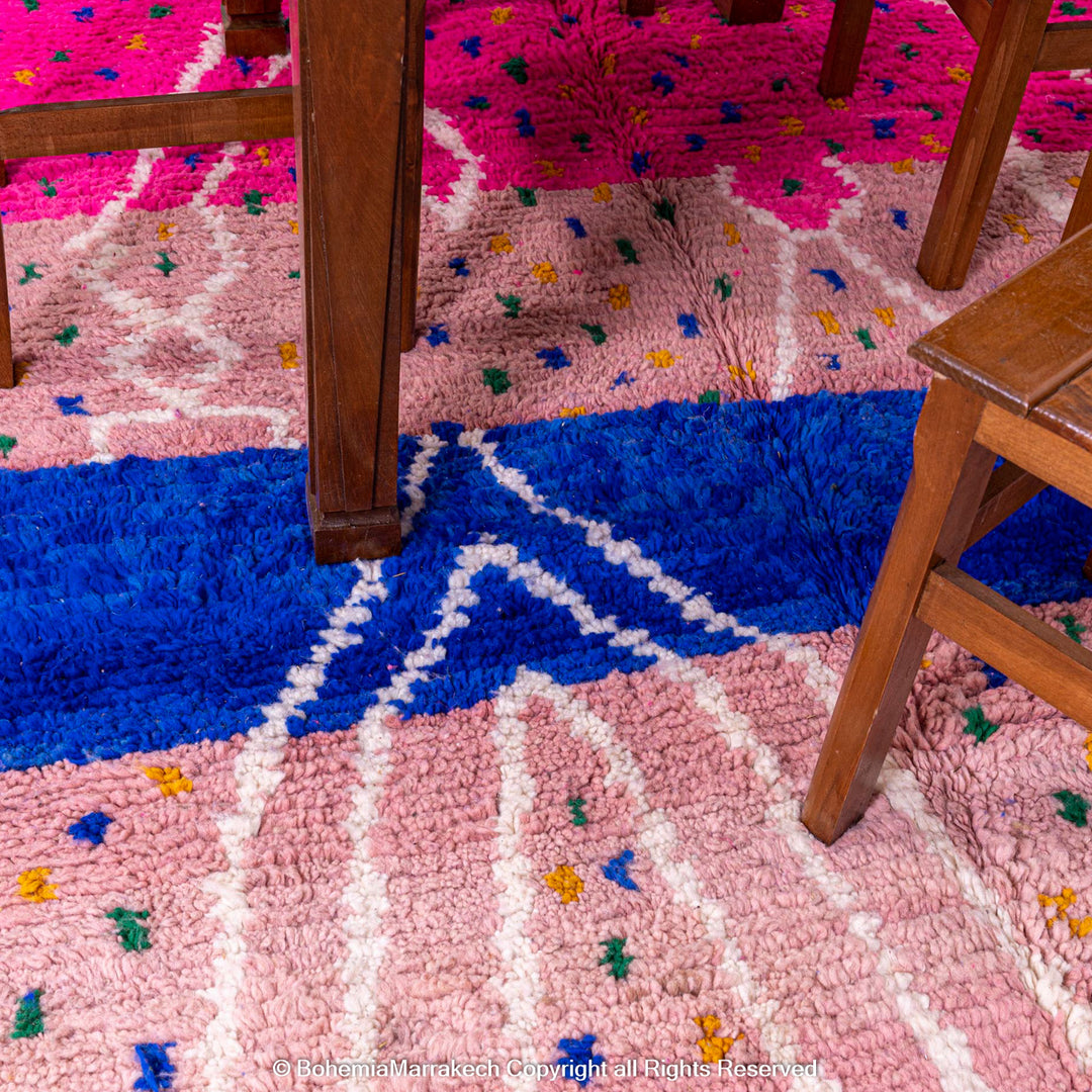 Pink and blue Moroccan rug with multicolor specks and geometric white lines