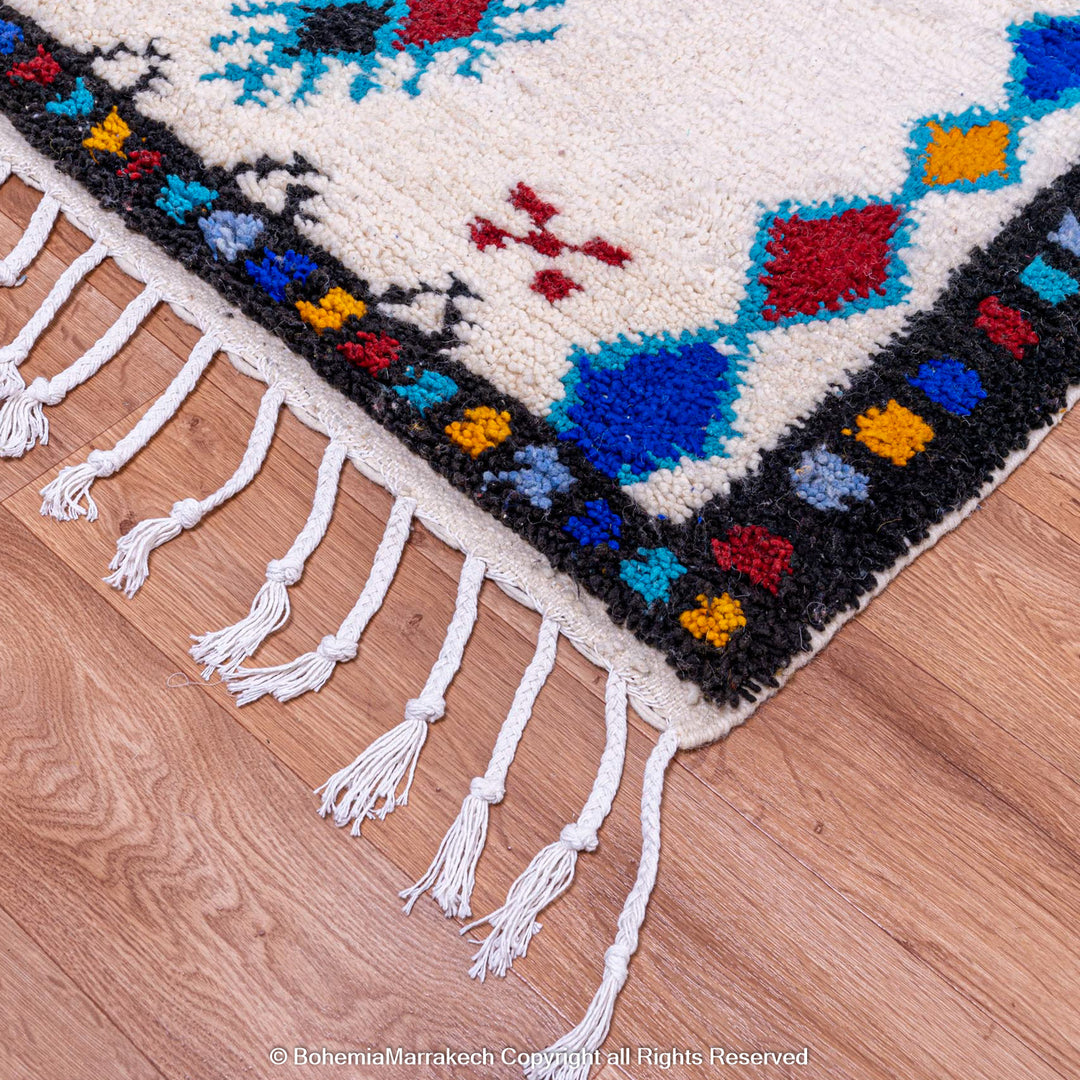 White Moroccan wool rug with colorful Berber tribal motifs and dark border – Beni Ourain handmade