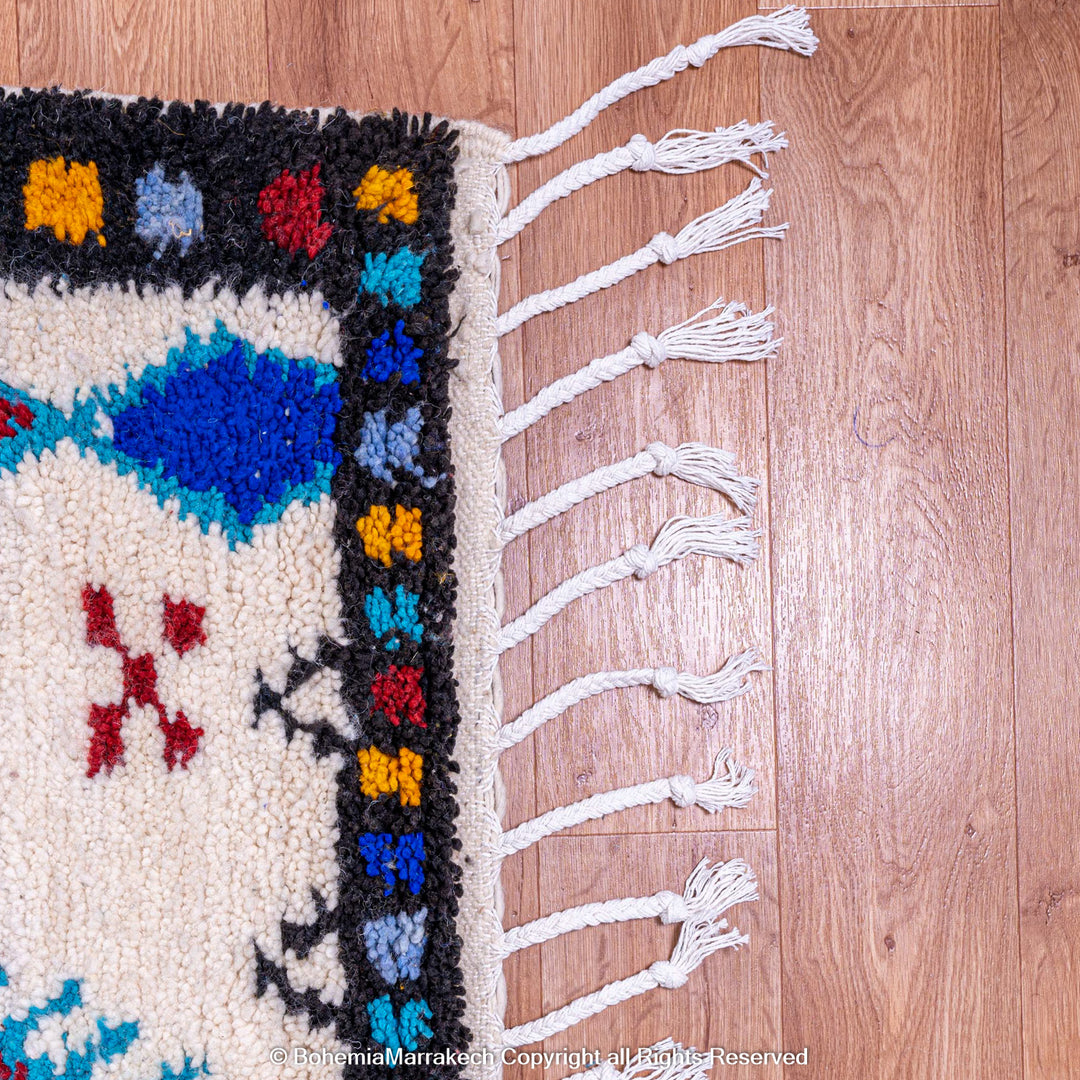 White Moroccan wool rug with colorful Berber tribal motifs and dark border – Beni Ourain handmade