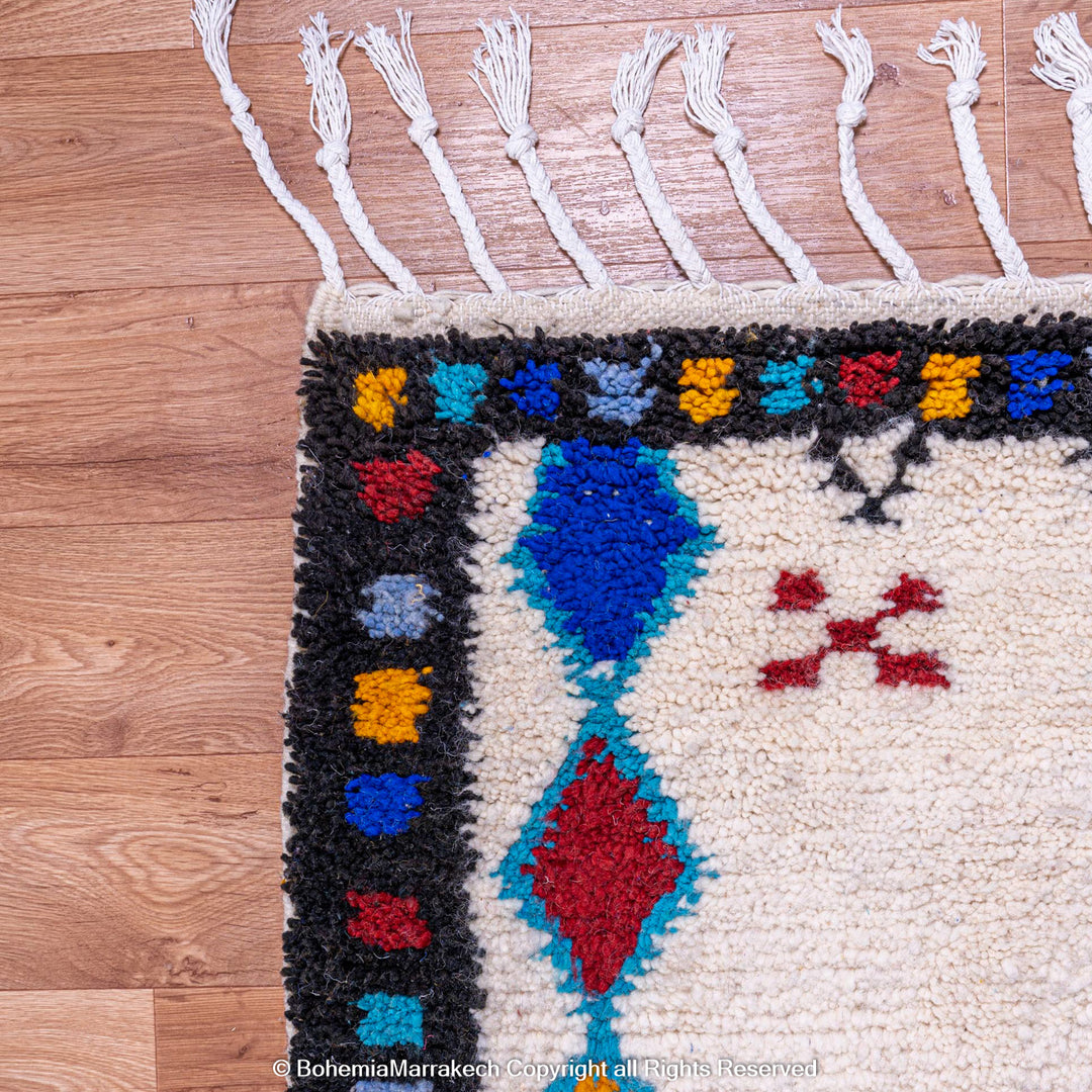 White Moroccan wool rug with colorful Berber tribal motifs and dark border – Beni Ourain handmade