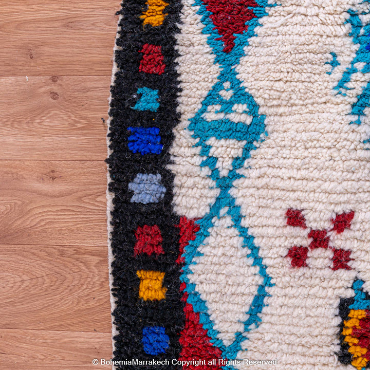 White Moroccan wool rug with colorful Berber tribal motifs and dark border – Beni Ourain handmade