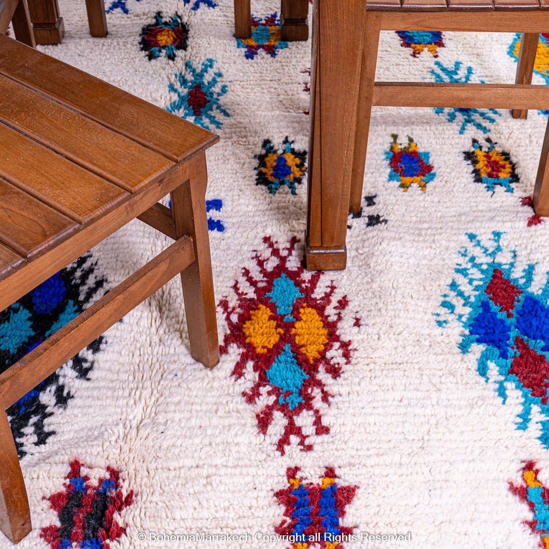 White Moroccan wool rug with colorful Berber tribal motifs and dark border – Beni Ourain handmade
