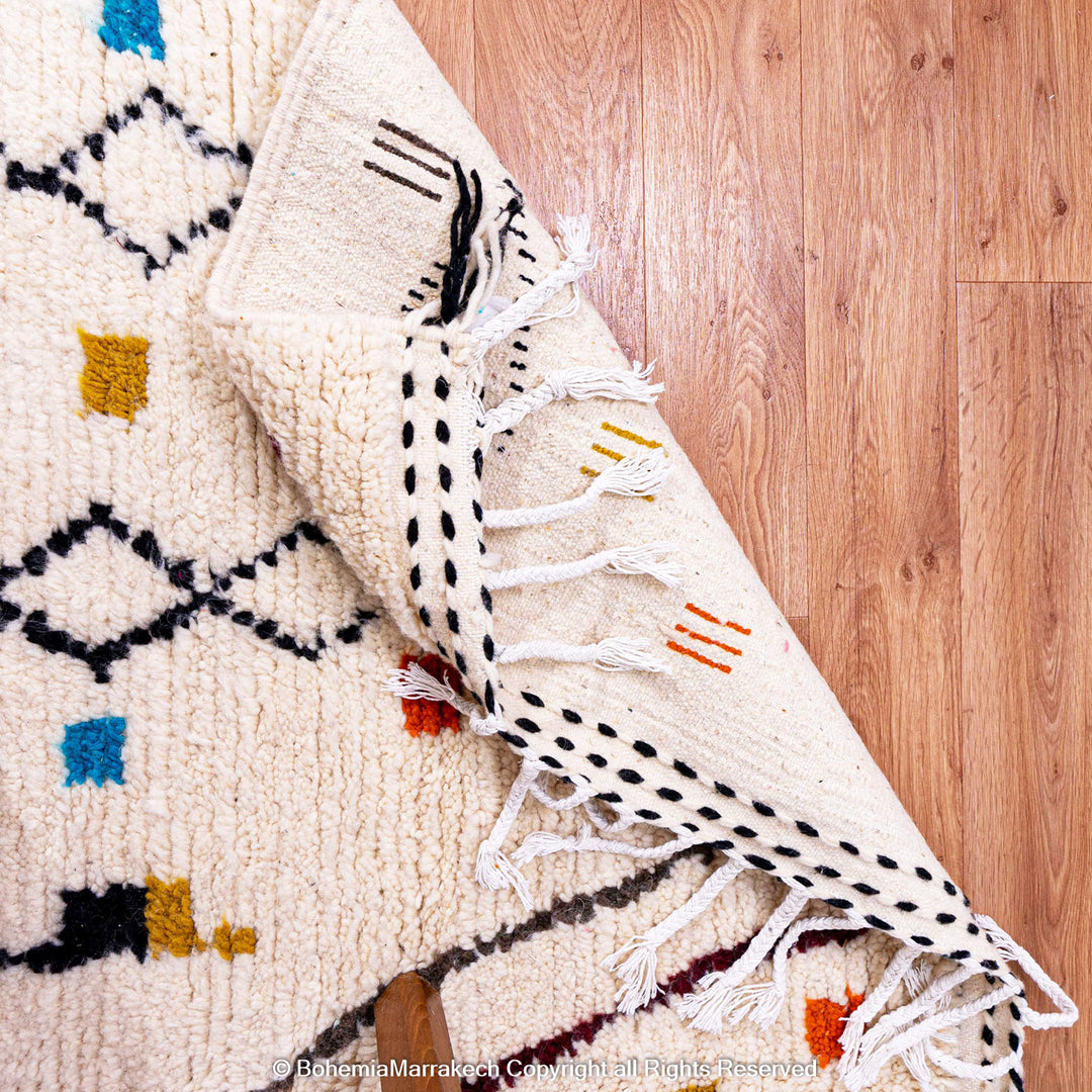 Abstract multicolored Azilal Moroccan rug with bold orange and yellow Berber motifs on wool background – handmade boho carpet