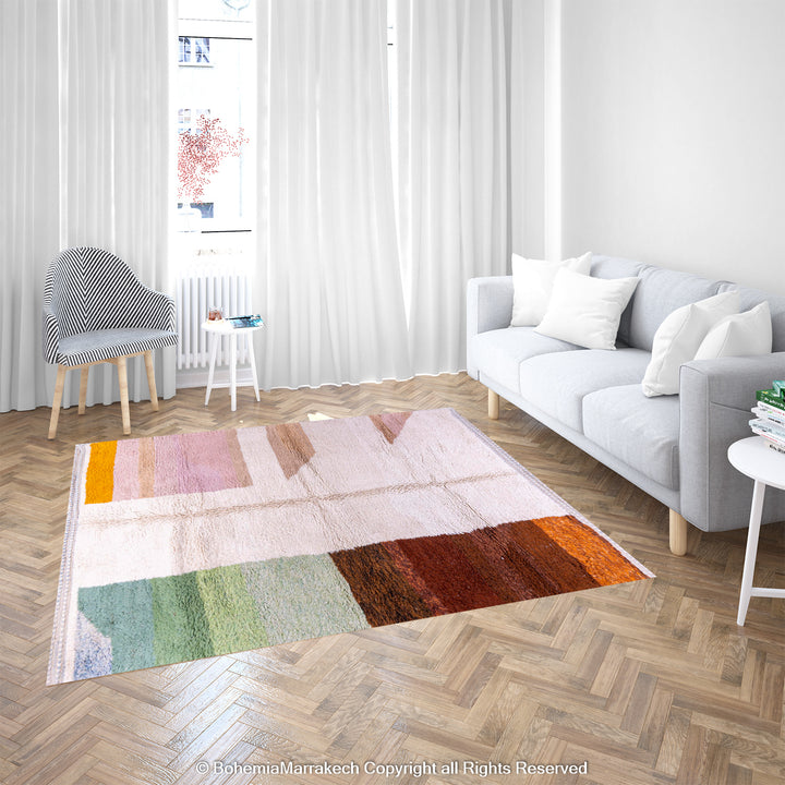 Colorful striped Moroccan wool rug in a modern living room with a sofa and chair, featuring bold color blocks and artisanal charm.
