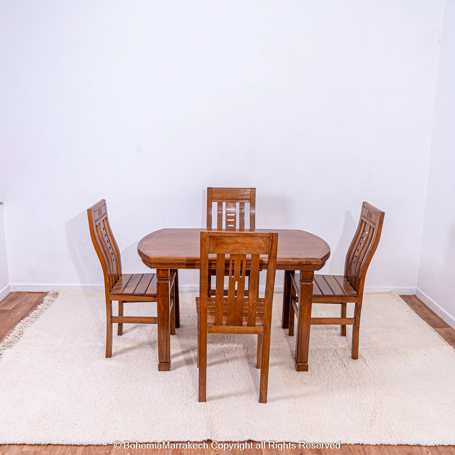 Plain white Moroccan wool rug under wooden dining table and chairs