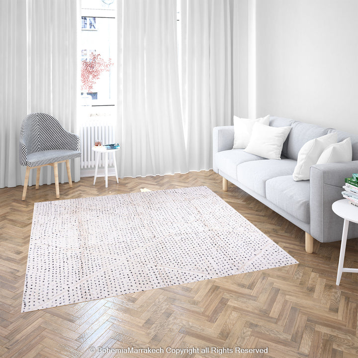 White Moroccan rug with black dots and diamond patterns in a bright living room, perfect for minimalist and boho interiors.
