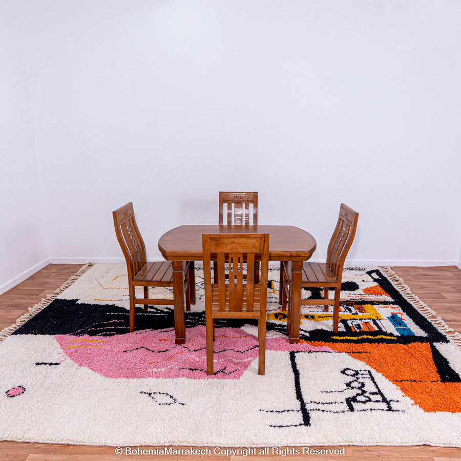 Abstract Face Moroccan rug with pink, yellow, orange motifs under wooden dining set; handwoven Berber wool art carpet.