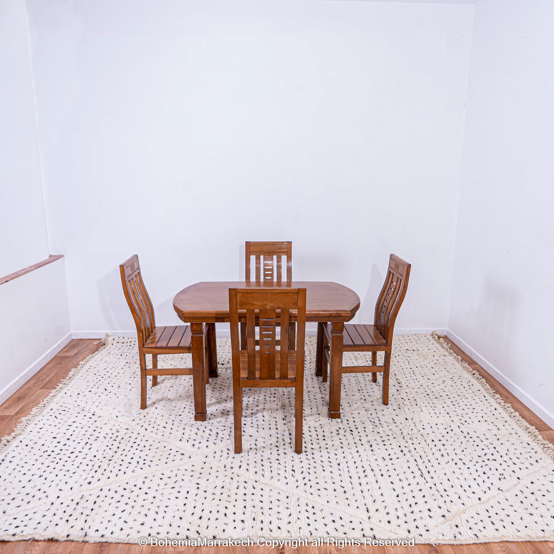 White Moroccan rug with black dot pattern under dining table, traditional Moroccan Berber rug for minimalist and boho interiors.