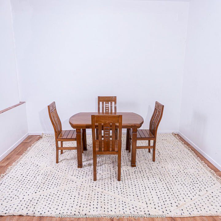 White Moroccan rug with black dot pattern under dining table, traditional Moroccan Berber rug for minimalist and boho interiors.