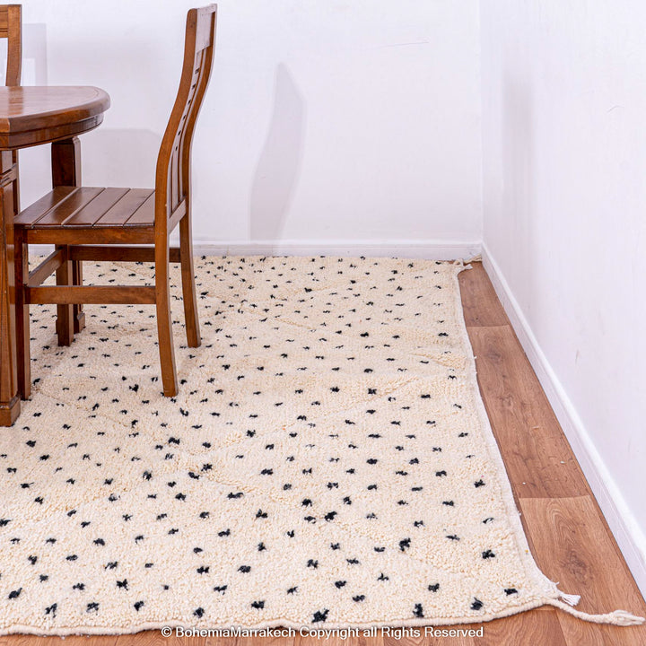 White Beni Ourain Moroccan rug with black dots in a dining room setting, made from natural wool, ideal for modern interiors.