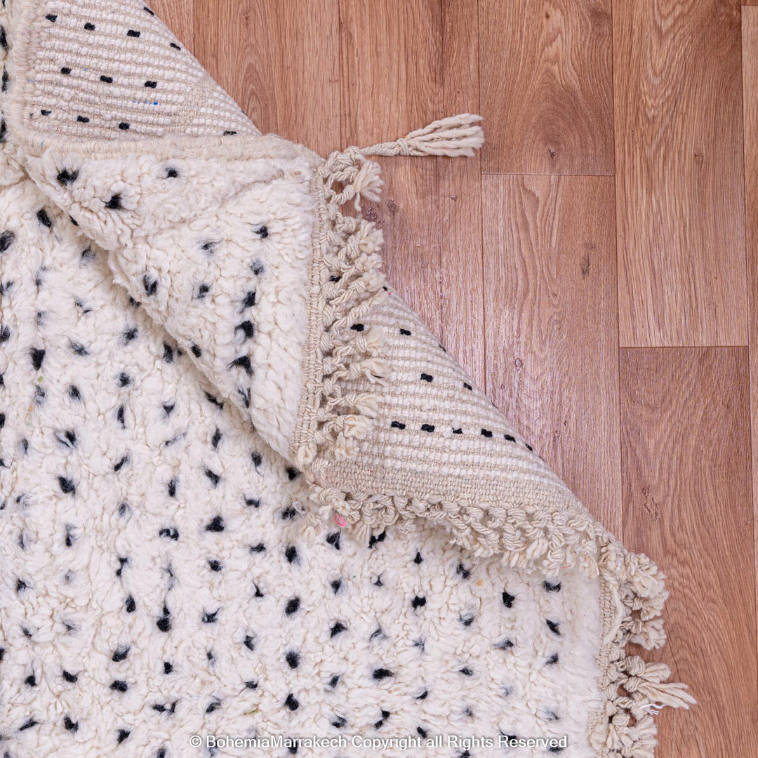 White Moroccan rug with black dots and diamond pattern, handwoven with natural wool, perfect for minimalist and boho interiors.