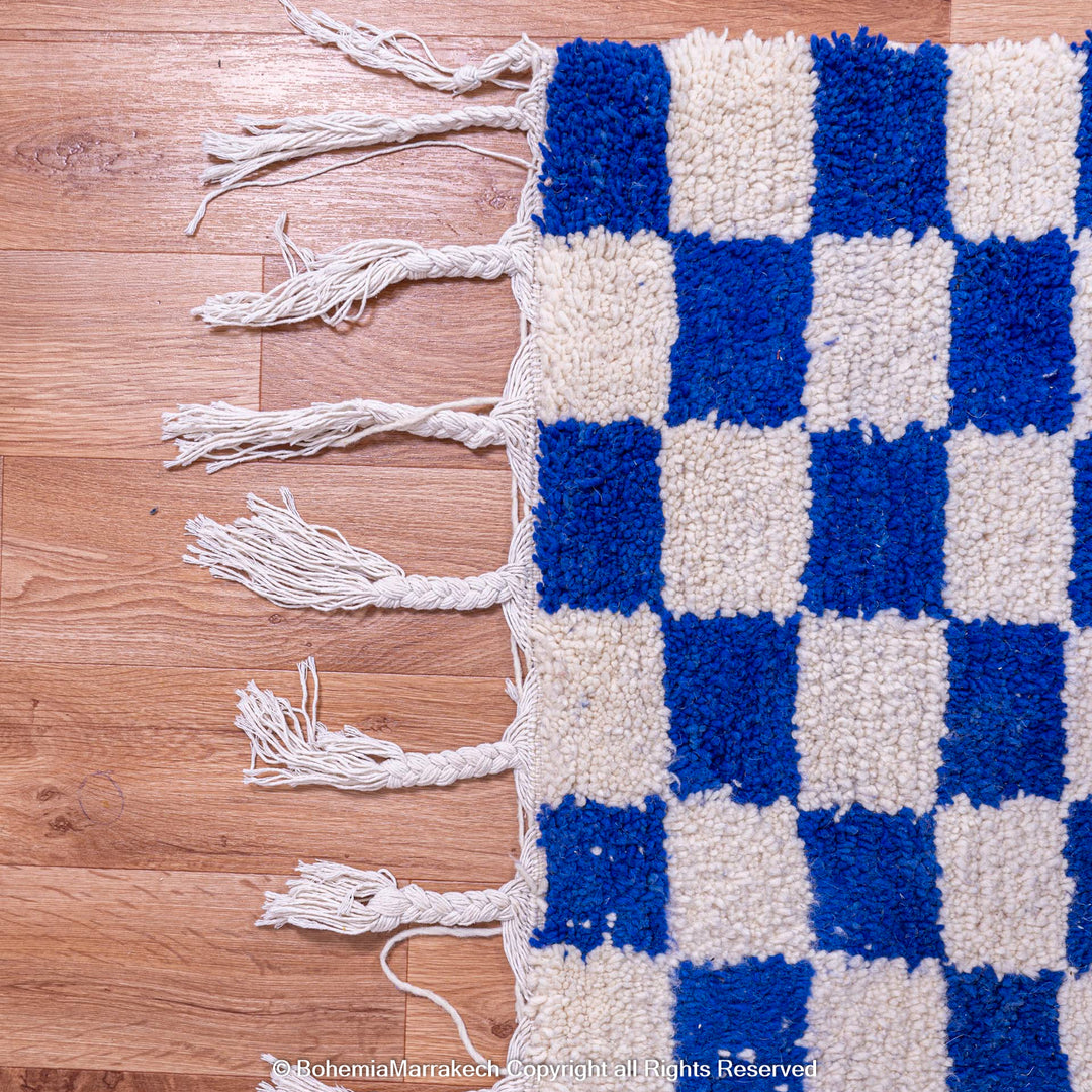 Blue white checkered Moroccan wool rug with fringes, handmade by Berber artisans, perfect for eclectic or minimalist interiors.