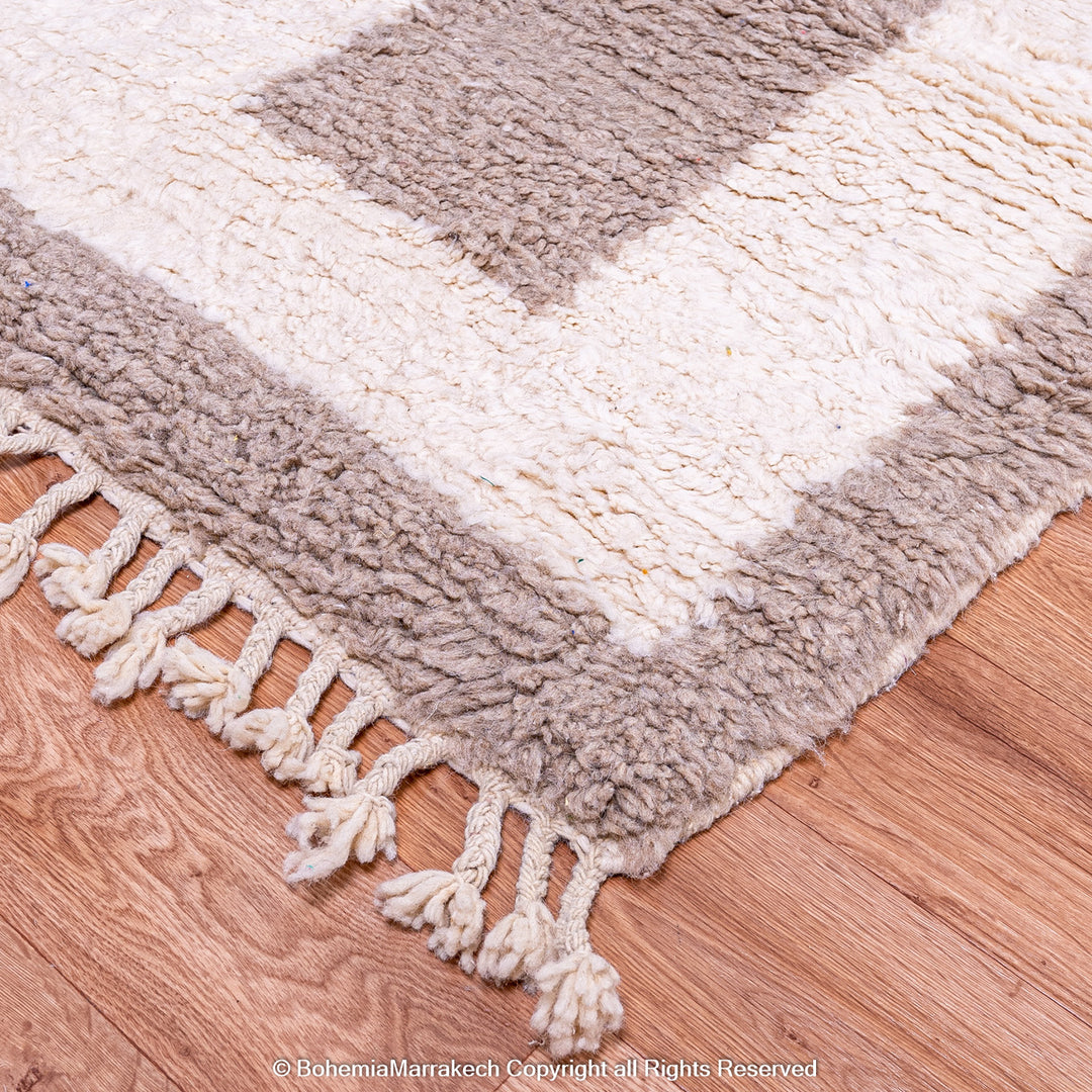 Minimalist Moroccan wool rug with beige border design on cream background