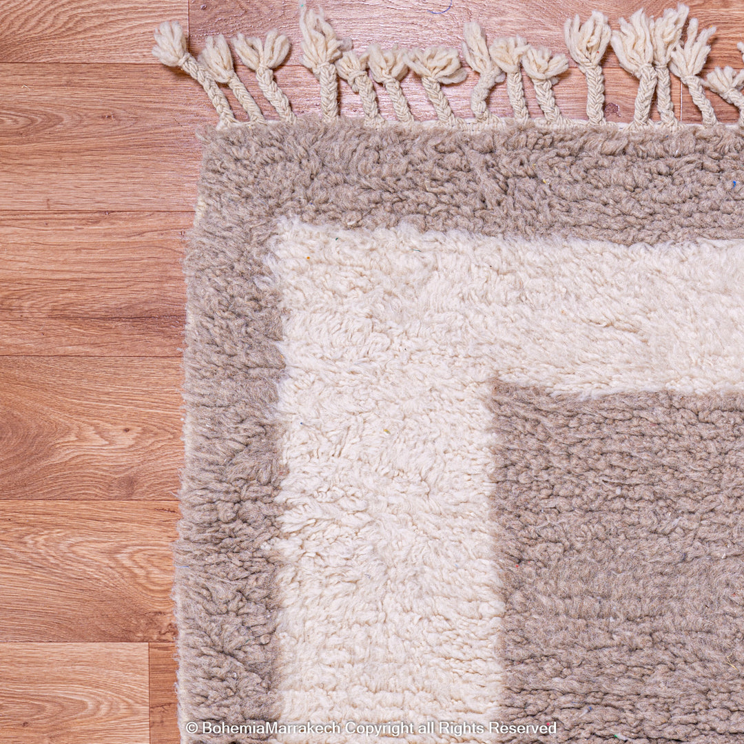 Minimalist Moroccan wool rug with beige border design on cream background