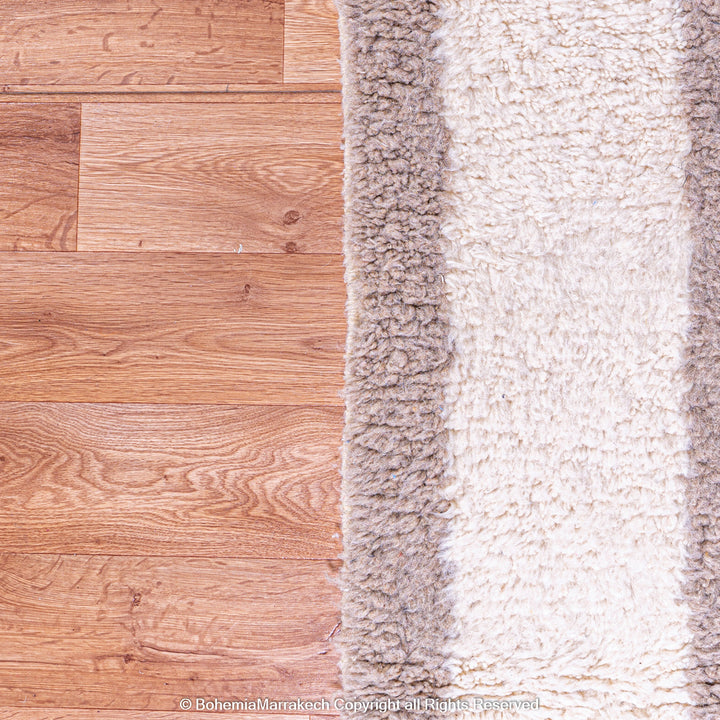 Minimalist Moroccan wool rug with beige border design on cream background