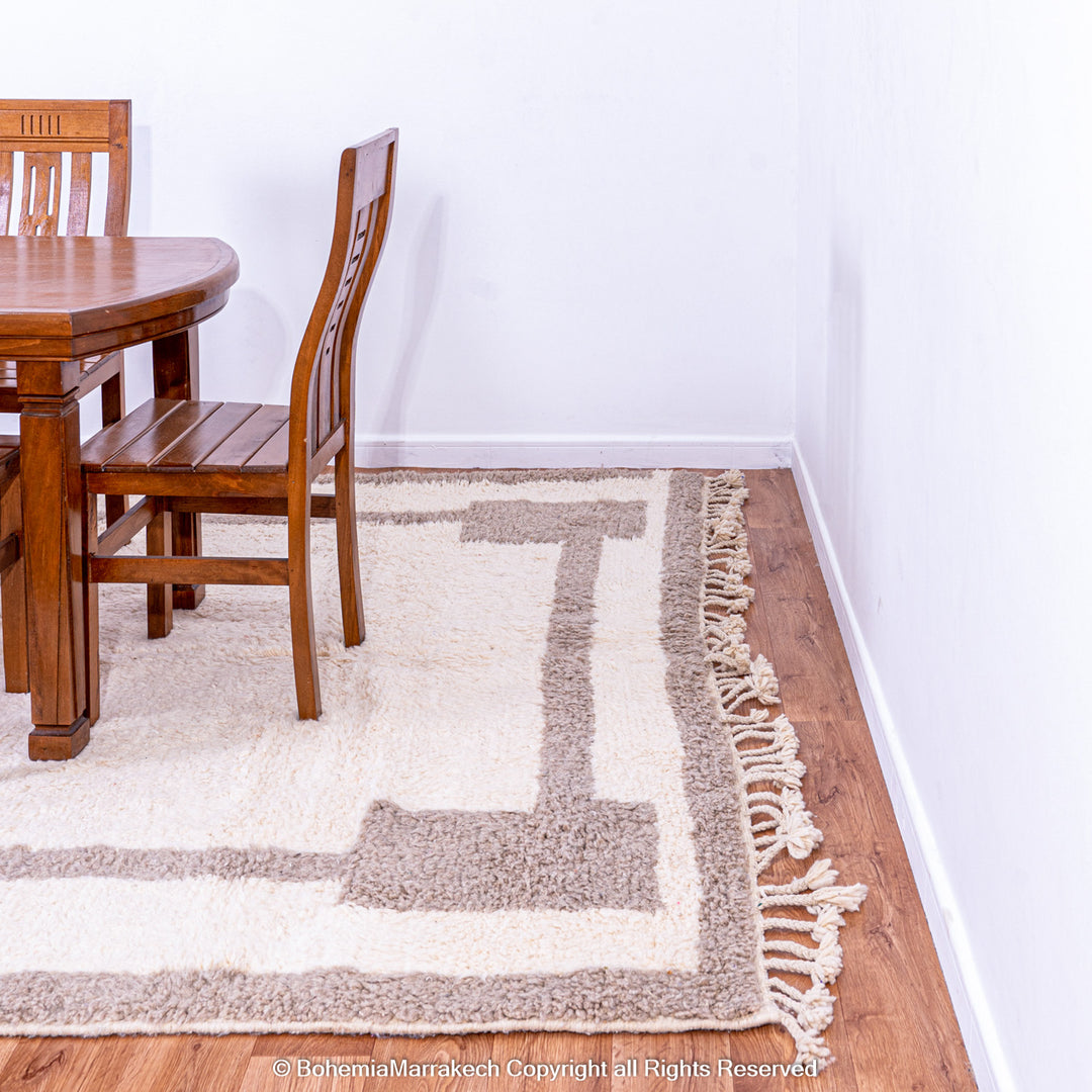 Minimalist Moroccan wool rug with beige border design on cream background