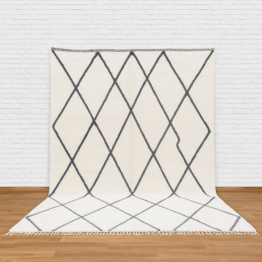 Geometric patterned rug on a wooden floor with a white brick wall background
